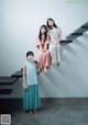 A group of three women sitting on top of a set of stairs.