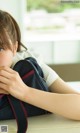 A young girl sitting at a table with a backpack.