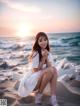 A woman sitting on a beach next to the ocean.